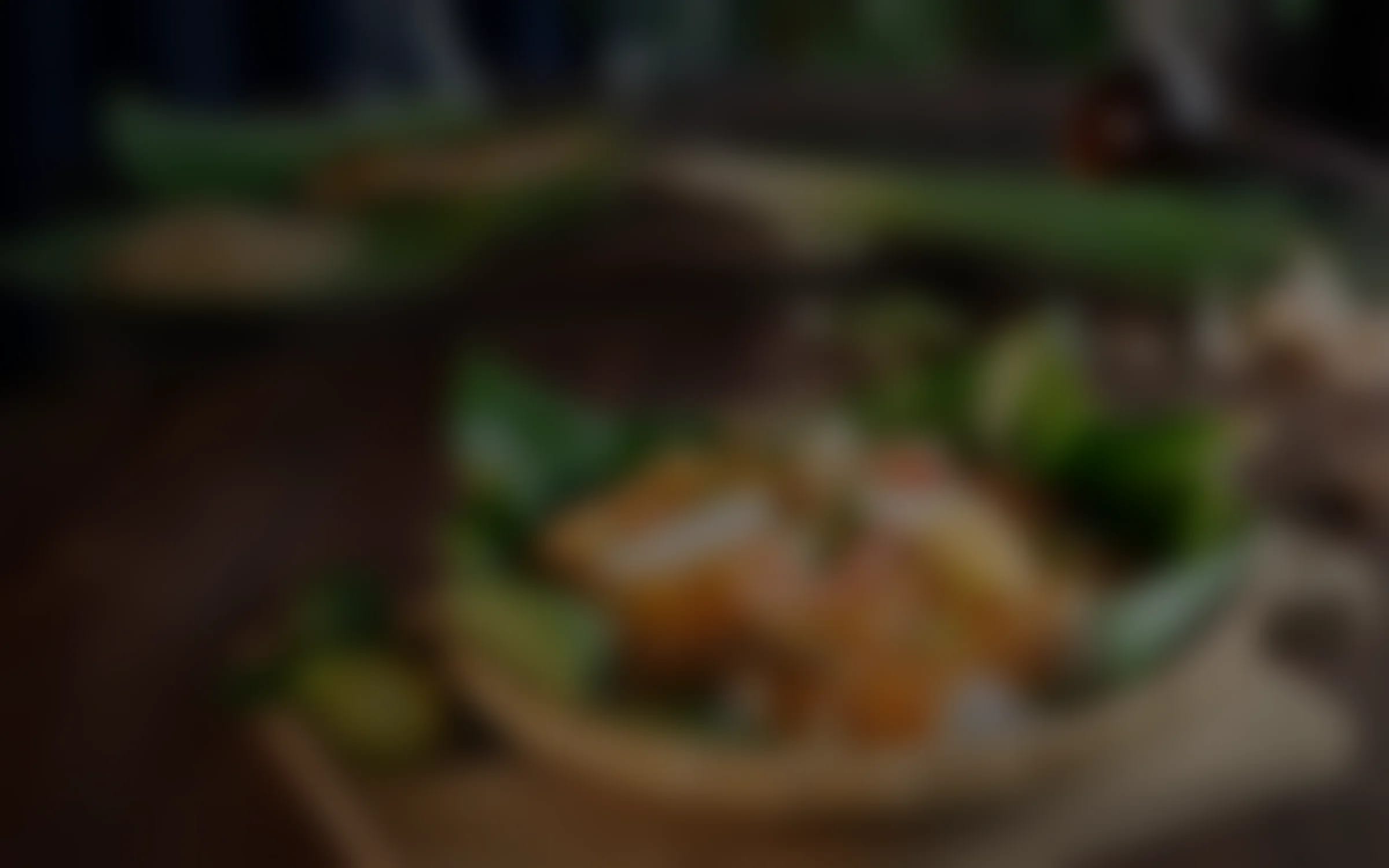 A wooden kitchen table set for palabok, out of focus