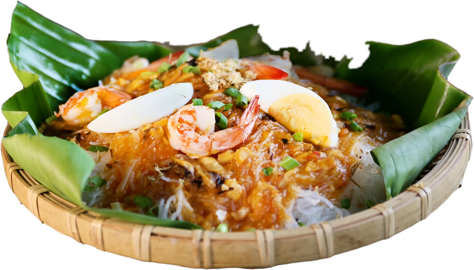 A basket of palabok on a banana leaf — rice noodles under shrimp, egg and chicharon